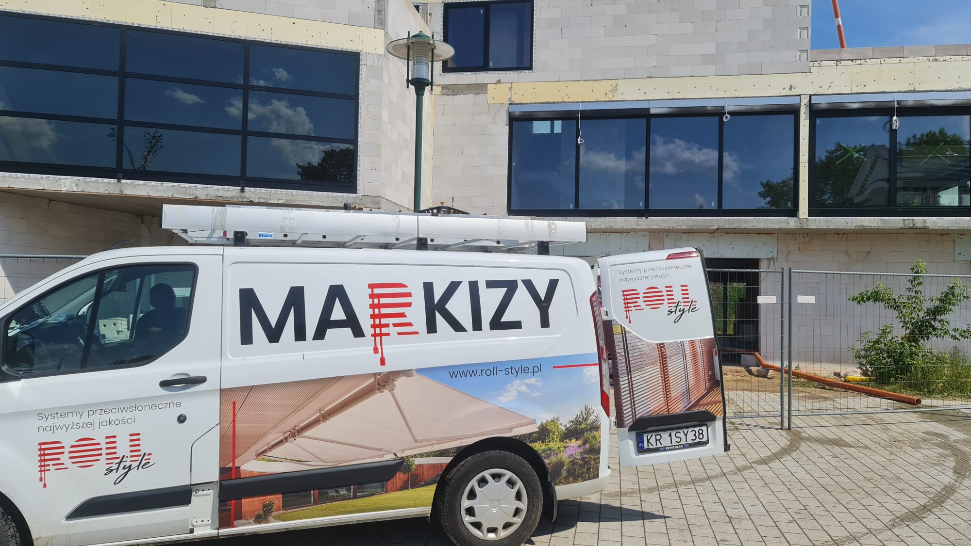 Bus firmowy Roll-Style z okleją MARKIZY na placu budowy